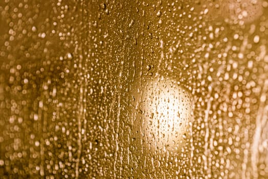 Close up of rain drops on the window in rainy night, cool lights