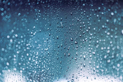 Close up of rain drops on the window in rainy night, cool lights