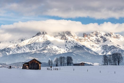 Snowy mountains, meadow and a hut, landscape in Austria