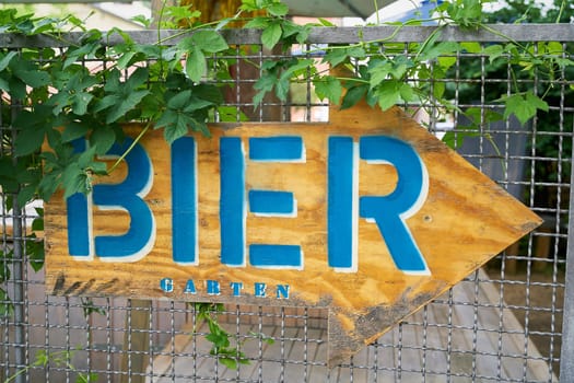 Sign with directional arrow with the inscription Bier garten (Beer garden) in the city center of Berlin