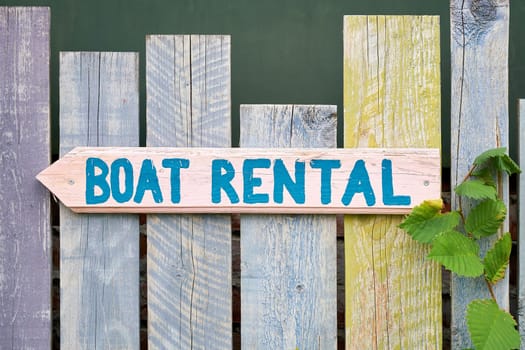 Sign with the inscription boat rental on a wooden fence on the river Spree in Berlin Kreuzberg in Germany
