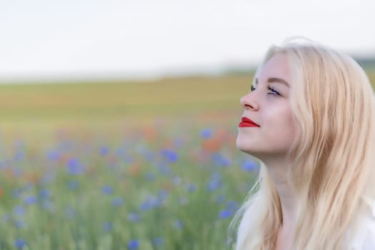 Side view of sunbathing beautiful young woman posing in summer field. Horizontally.