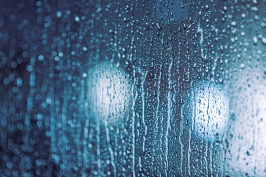 Close up of rain drops on the window in rainy night, cool lights