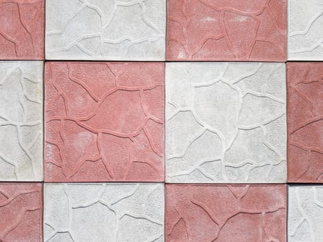concrete coating of gray and red colors. Sidewalk of gray and pink pavers close-up. Texture, background from curly gray-orange stone. Top view on the sidewalk.