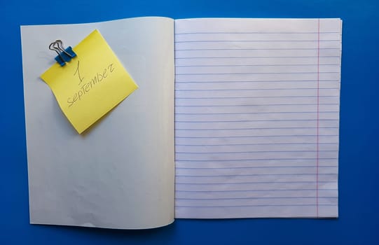 Open notebook on a white lining on a blue wooden tabletop.