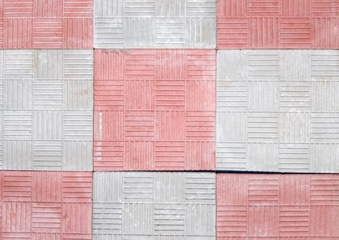 concrete coating of gray and red colors. Sidewalk of gray and pink pavers close-up. Texture, background from curly gray-orange stone. Top view on the sidewalk.