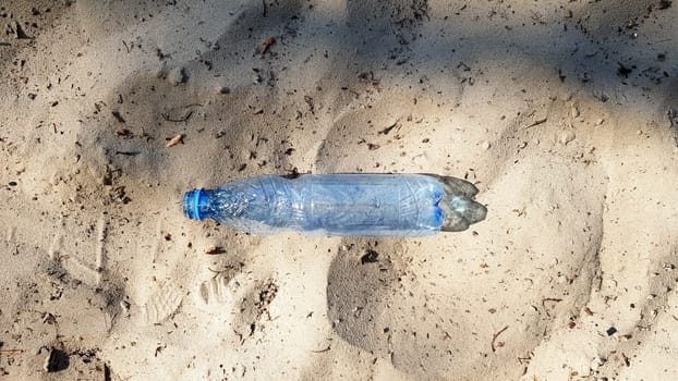 The bottle is plastic. Ecology, plastic pollution. Ocean pollution. Plastic in the sand. Trash on the beach concept. artificial pollution and poster. World Promotion Week. We clean the world. We clean the planet from debris.