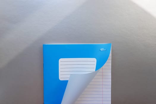 Design concept - Top view of a high quality male hand leafing through a sheet of blue striped notebook. Top view, copy space, flat lay.
