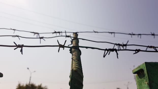 Barbed wire. Barbed wire on fence with blue sky to feel worrying. The silhouette of the old barbed wire fence and the sky at twilight