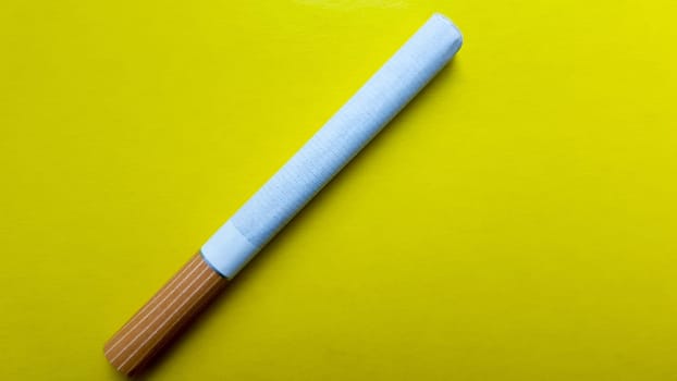 Cigarettes isolated diagonal on a yellow background.