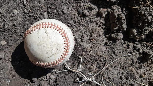 Closeup White leather textured baseball ball with red seams. Ball Outside Stadium Home Run Concept.