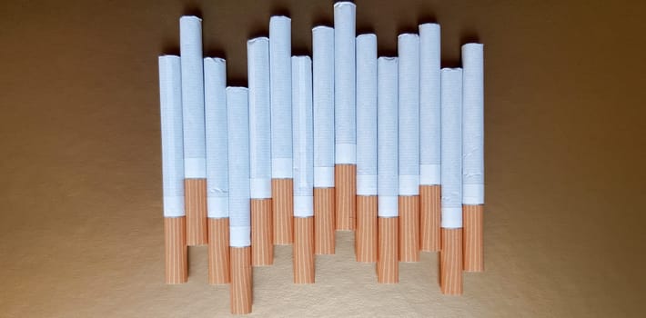 Image of several commercial cigarettes. pile of cigarettes on a gold background or concept of anti-smoking campaign, tobacco.