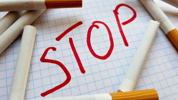 A sticker that says Stop is in a pack of cigarettes. World No Tobacco Day. Quit smoking. Fight with cigarettes.