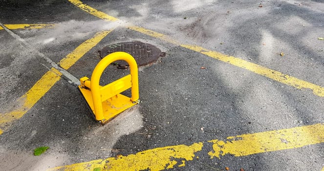 Orange iron parking barrier on the street. A foldable barrier prevents parking at this location. car security.