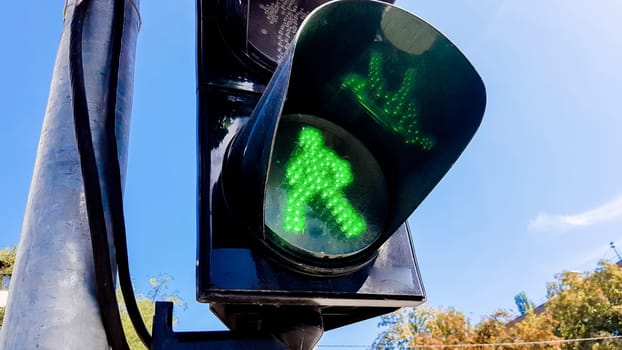 Traffic light with green light and safe for movement. Pedestrian traffic light. Green man.