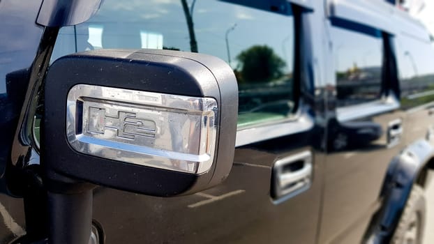 Ukraine, Kiev - August 29, 2019: side mirror on a modern large black Hammer car from the outside on a blurred background.