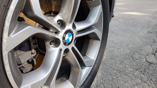 Ukraine, Kiev - August 28,2019 Original BMW alloy wheel dirty and scratched with tires on a car close-up.