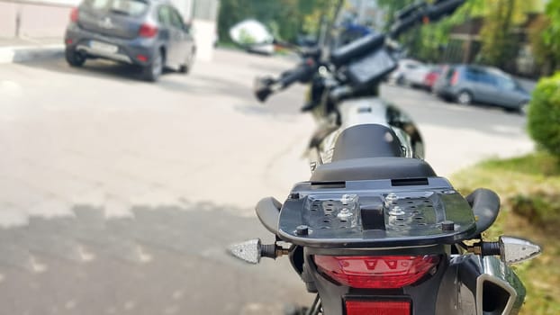 Black motorcycle parked. Back view. Soft focus.