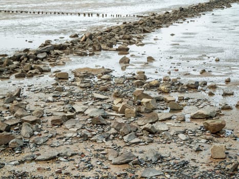 Landscape view with boulders in the Wadden Sea on the German North Sea beach at low tide.