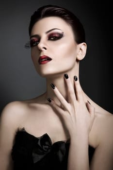 Glamour portrait of young red haired woman against grey background