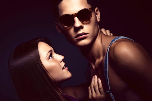 Fashion portrait of young beautiful couple against blue background