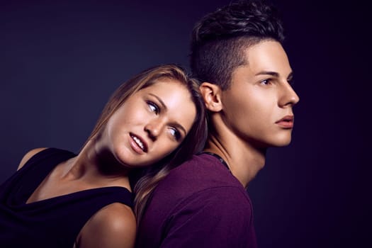 Fashion portrait of young beautiful couple against blue background