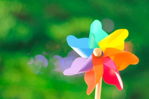 Colorful Pinwheel Toy Against green bokeh background of summer. Spinning pinwheel toy. Garden Ornaments Windmills & Wind Spinners Colorful Garden Wooden Handle Windmill Pinwheel Wind Spinner Yard decor
