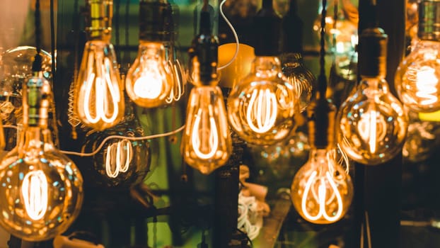 Many different vintage light bulbs hanging . Decorative hanging ceiling light. Decorative antique Edison style light bulbs against brick wall background .
