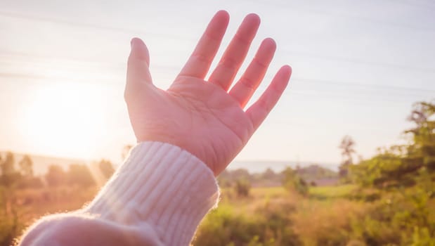 soft focus Woman hand reaching towards nature and sky
