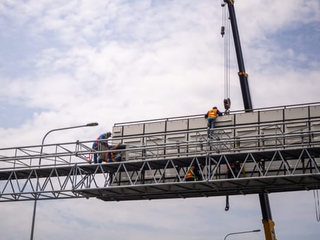 Construction site crane is lifting a led signboard Blank billboard on blue sky background for new advertisement