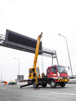 Construction site crane is lifting a led signboard Blank billboard on blue sky background for new advertisement