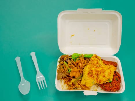 Thai food, stir fried crispy pork basil in foam box.