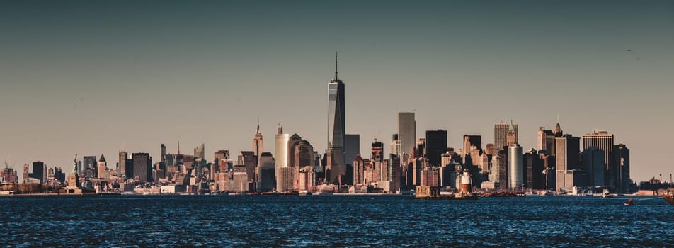 New York City Manhattan downtown skyline at dusk with skyscrapers illuminated over Hudson River panorama. Vertical composition.