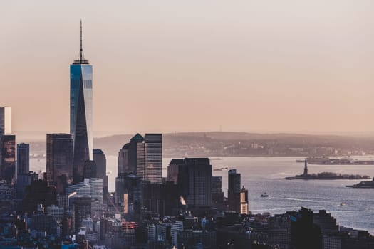New York City. Manhattan downtown skyline with illuminated Empire State Building and skyscrapers at sunset.