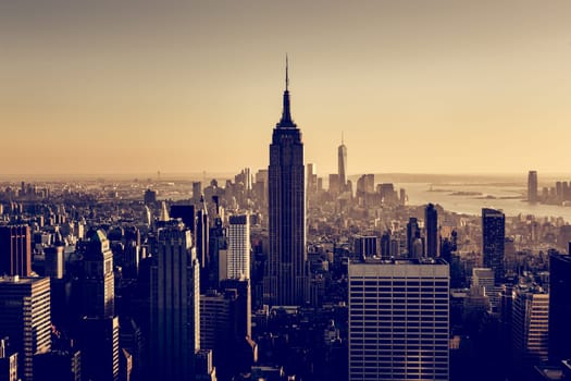 New York City. Manhattan downtown skyline with illuminated Empire State Building and skyscrapers at sunset.