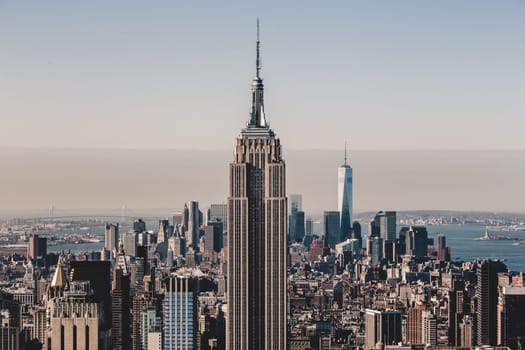 New York City. Manhattan downtown skyline with illuminated Empire State Building and skyscrapers at sunset.