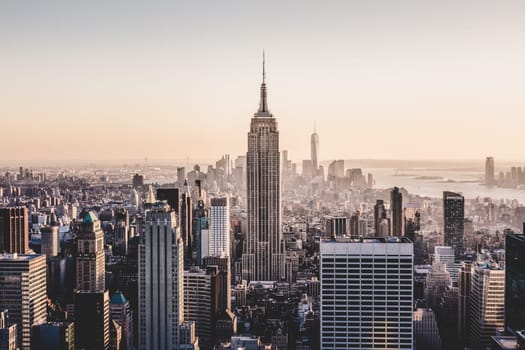 New York City. Manhattan downtown skyline with illuminated Empire State Building and skyscrapers at sunset.
