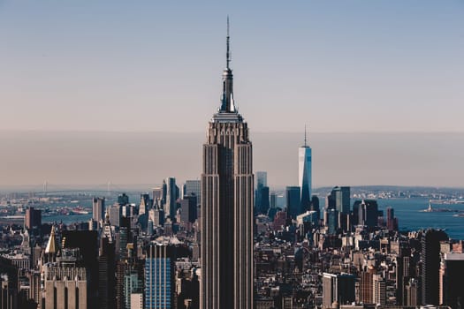 New York City. Manhattan downtown skyline with illuminated Empire State Building and skyscrapers at sunset.