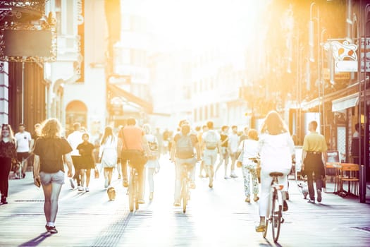 Blurred crowd of people on Copova pedestrian street in Ljubljana at sunset. Urban lifestyle and mobility concept