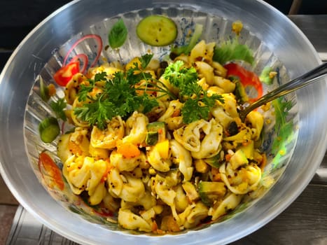 Bowl of fusili pasta salad with fresh vegetables