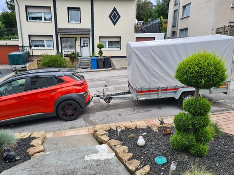 Compact SUV with gray awning single-axle trailer up close .Car with trailer. Trailer with awning. Big suv. Side view