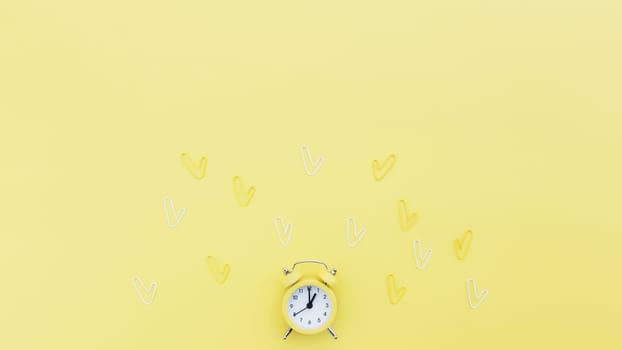 Back to school, office work conceptual flat lay with alarm clock, clips and copy space area for text. Concept of time to work, be in time and wake up early idea. Yellow background and alarmclock