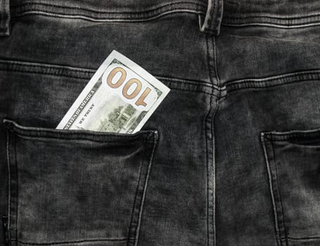 Many hundred dollar bills in jeans pocket. US dollars are visible in your pocket