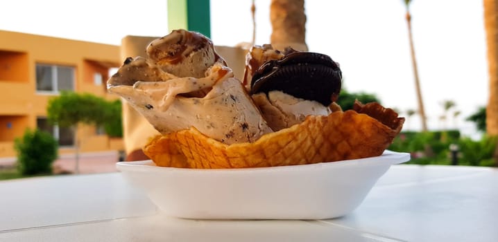 A serving of fried ice cream with caramelized banana cream cookies on a white table summer cafe.
