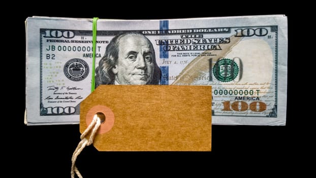 Empty cardboard tag for inscription black friday with american dollars on black background. Background, concept for the holiday Black Friday - the international day of shopping, stocks, discounts, sales. Sales season on the fourth Thursday of November. Copy space, place for text, flat lay.