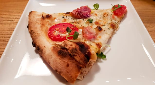 A single slice of cheese pizza on a white plate.