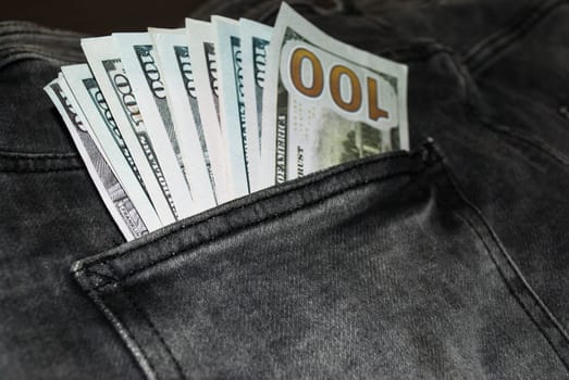 Many hundred dollar bills in jeans pocket. US dollars are visible in your pocket
