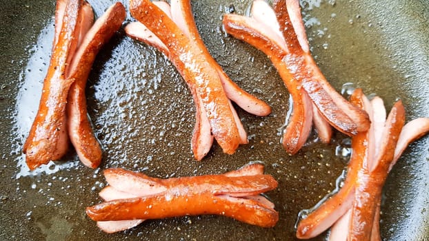 Grilled octopus sausages for children in a hot pan.