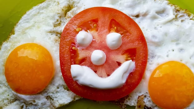 fried eggs with vegetables on a green plate, served to children.