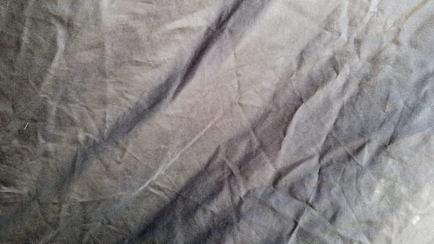 A black color fabric pattern texture background. Close up of beautiful wrinkle black fabric texture